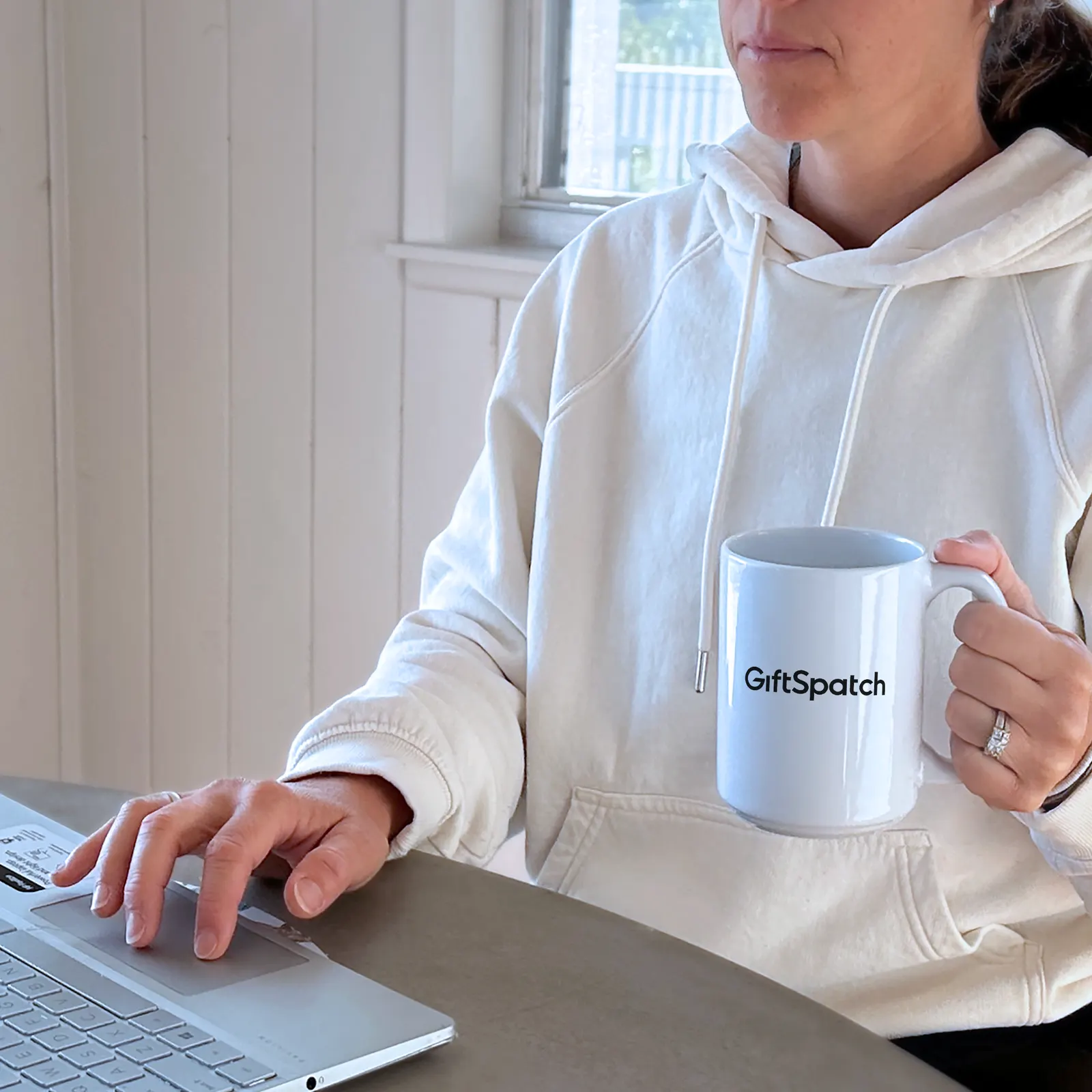 A branded mug beside a laptop